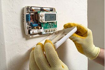 Thermostat cover removed, wiring and circuit board exposed